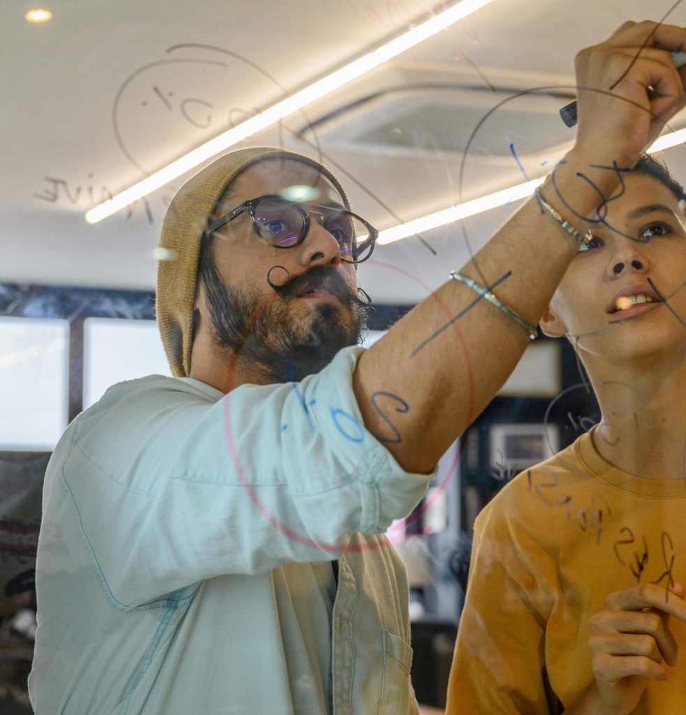 Eine Gruppe von Erwachsenen unterschiedlicher Herkunft sammelt in einem modernen Büro auf Glas Ideen.